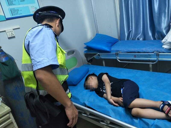 三亚路管员协助医护人员把昏迷男孩推进急救室进行救治.三亚警方供图.